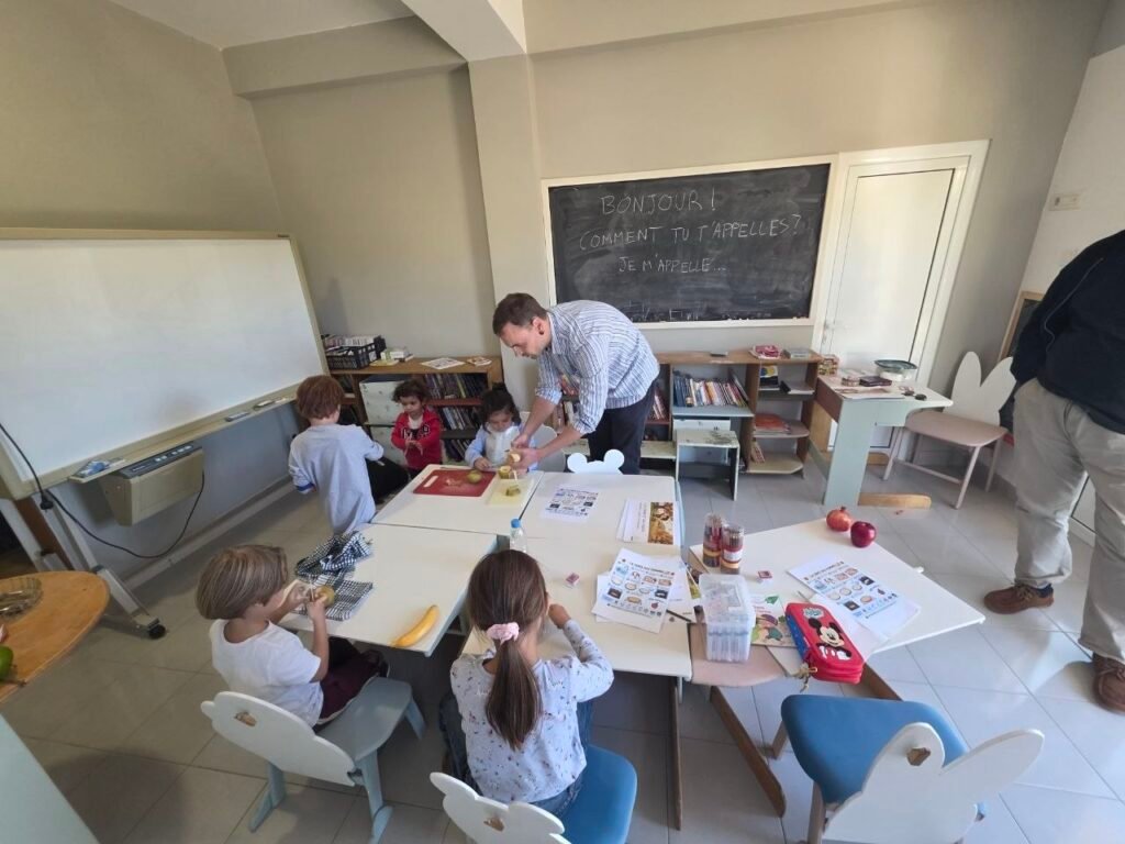 Classe en lumière naturelle : mains, bois clair et matériel d'atelier